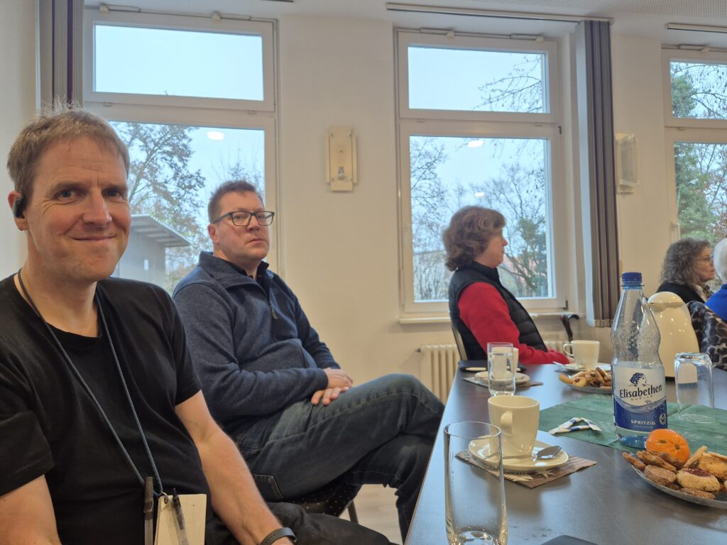 Menschen, die in einem Raum sitzen und der redenden Person zuhören