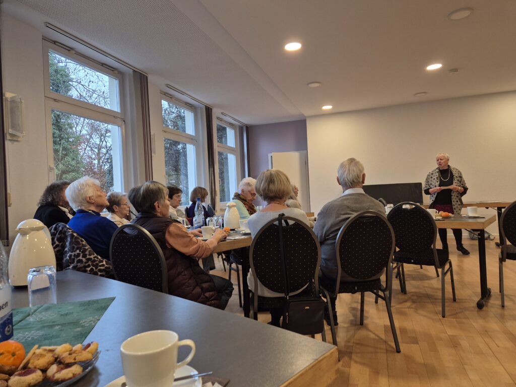 Menschen, die in einem Raum sitzen und der redenden Person zuhören