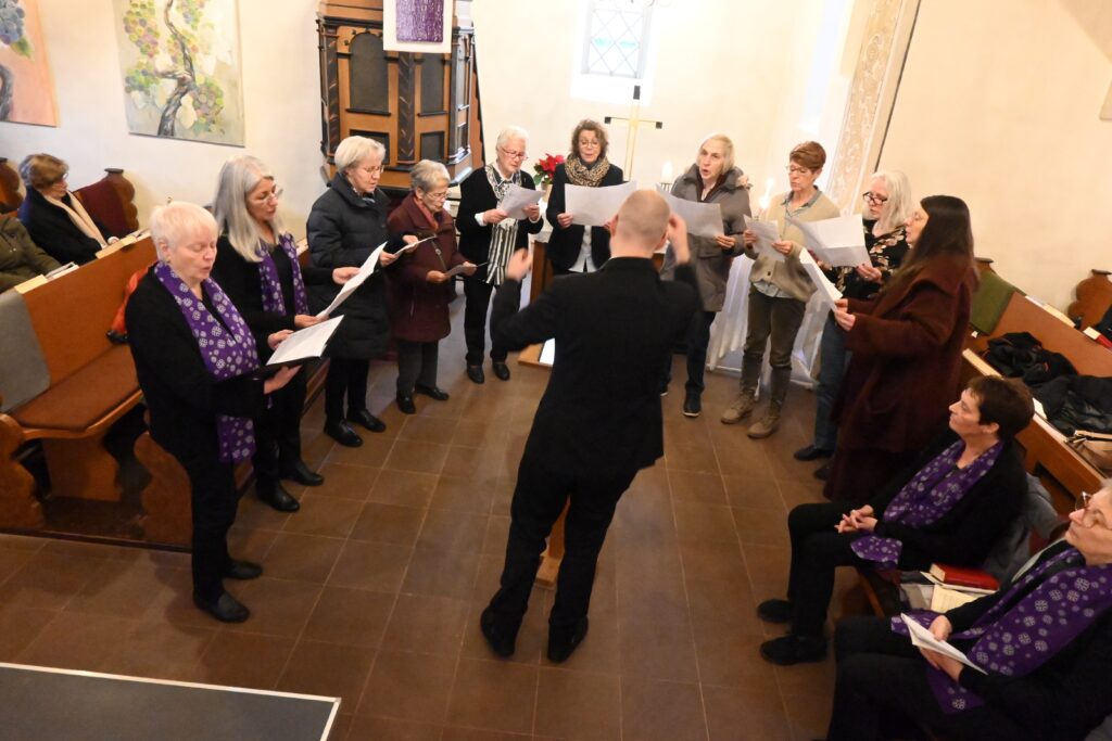 Chor steht singend vor dem Altar
