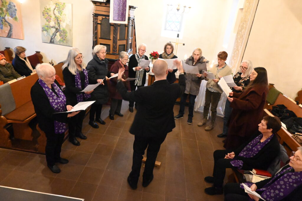 Chor steht singend vor dem Altar