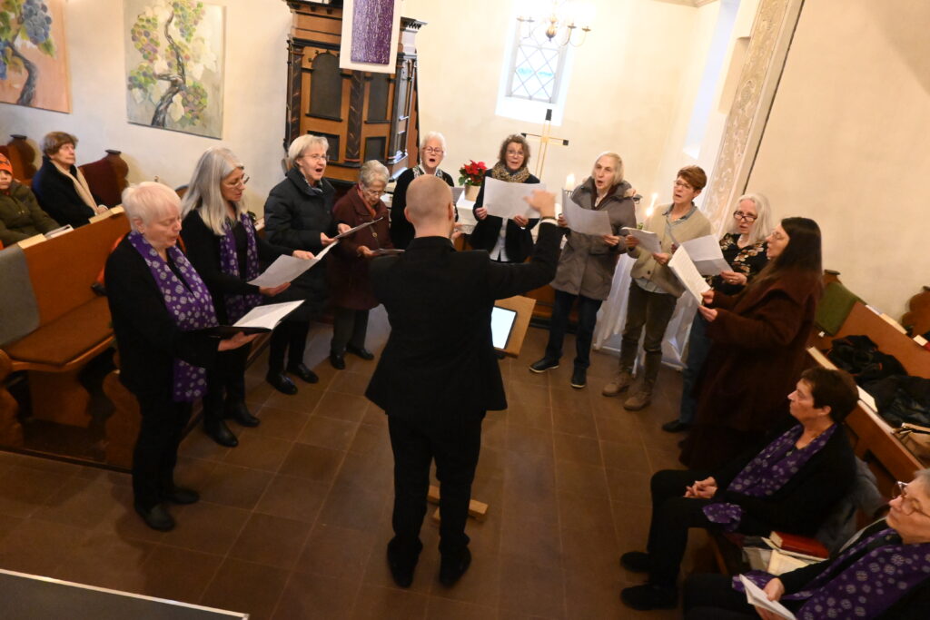 Chor steht singend vor dem Altar