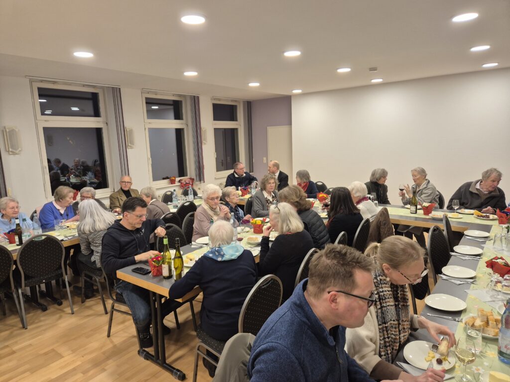 Mehrere Menschen sitzen an Tischen und essen. 