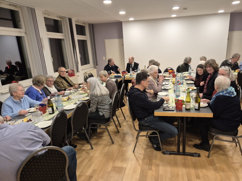 Mehrere Menschen sitzen an Tischen und essen. 