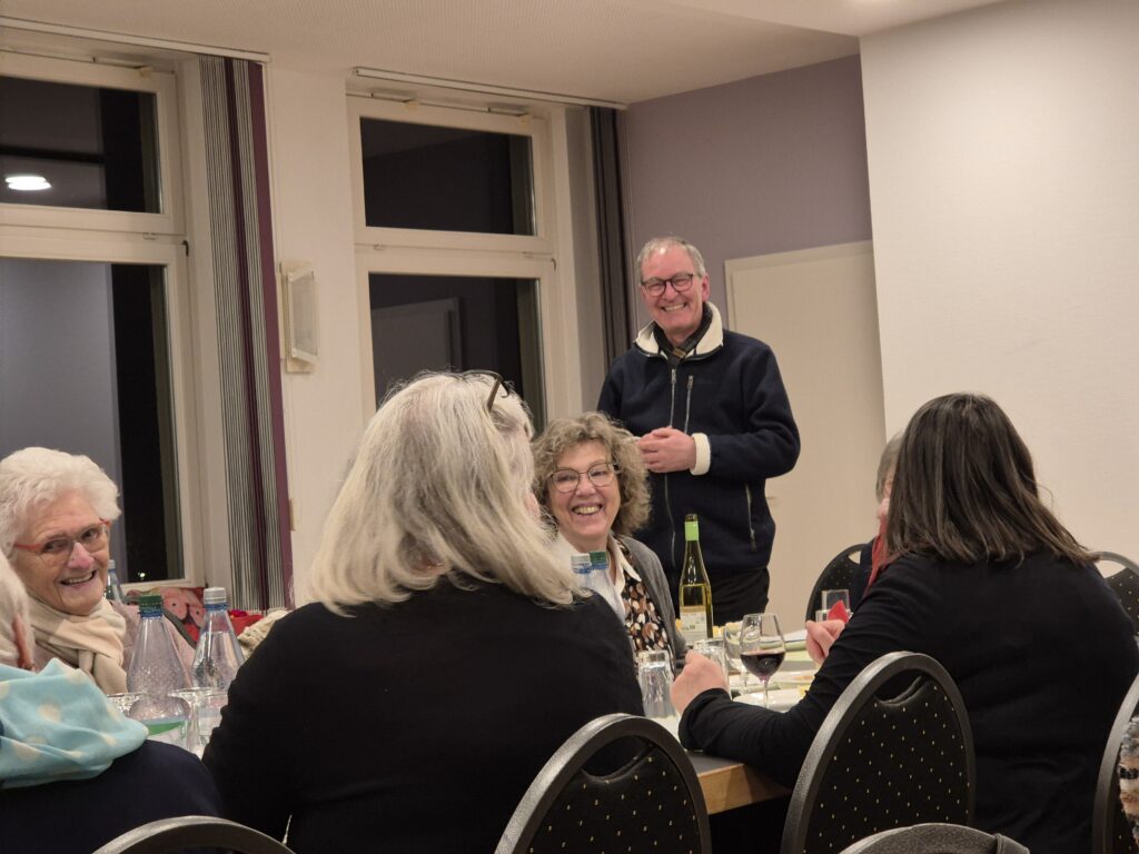 Mehrere Menschen sitzen an Tischen und essen. 