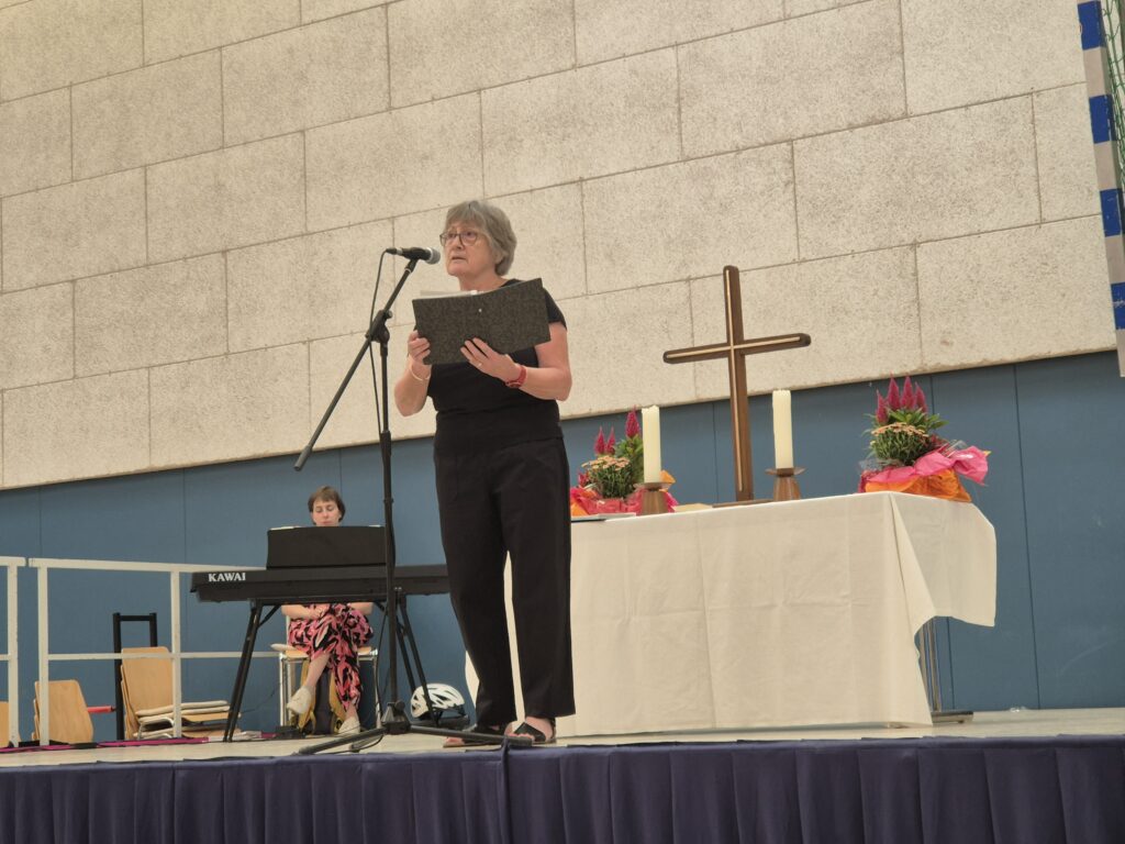 Christine Klaus vor dem Altar auf der Bühne und im Hintergrund die Organistin.
