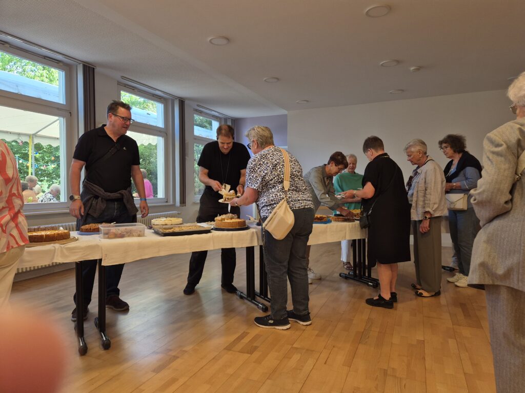 Menschen stehen an der Kuchentheke