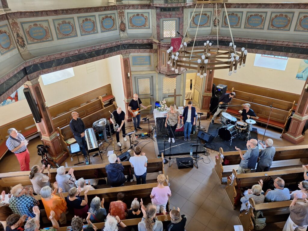 Foto von oben, das die Band und Publikum zeigt.