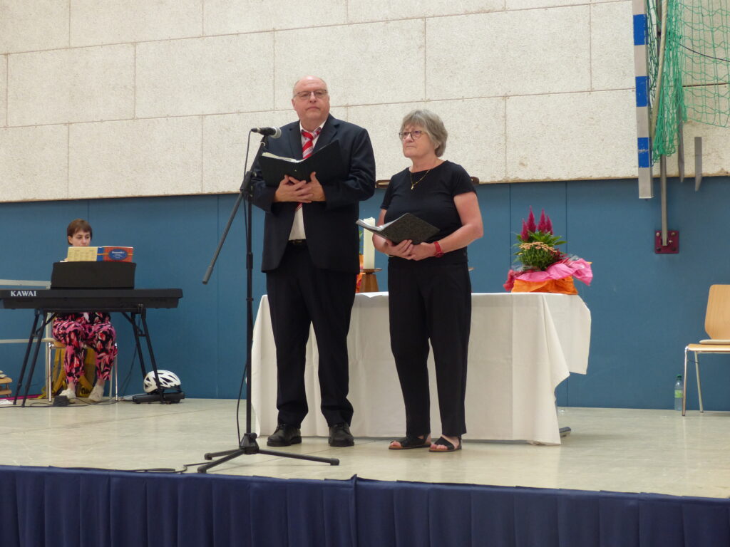 Martin Maurer und Christine Klaus vor dem Altar auf der Bühne und im Hintergrund die Organistin.